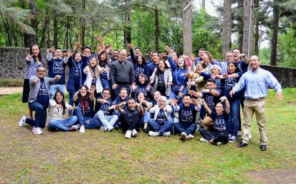 Fotografía grupal de un encuentro de emprendedores en un bosque