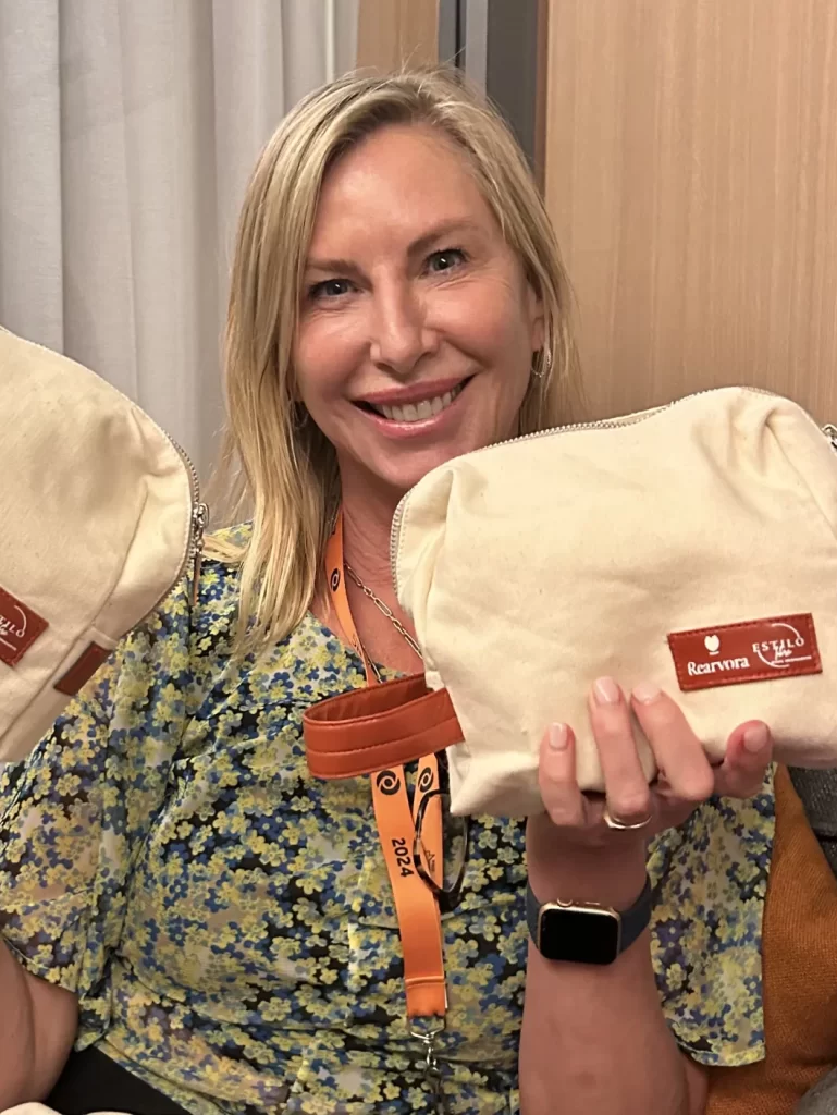 Mujer sonriendo mientras muestra bolsas de tela con productos Rearvora